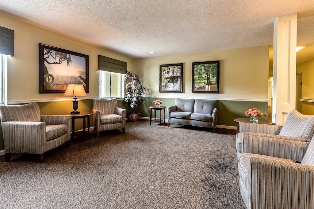 A cozy living room with comfortable seating, warm lighting, and decorative wall art.