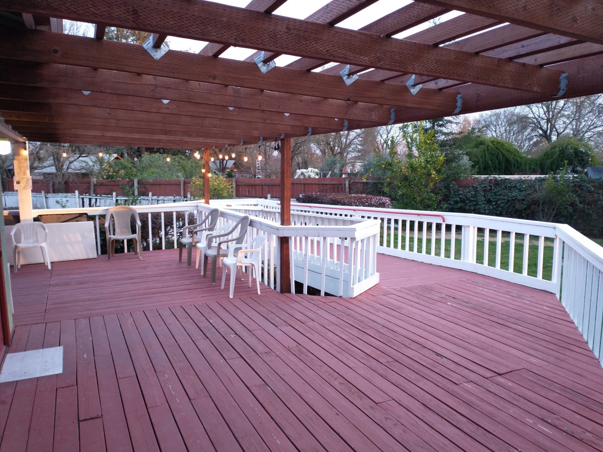 A spacious outdoor deck with a pergola and seating area.