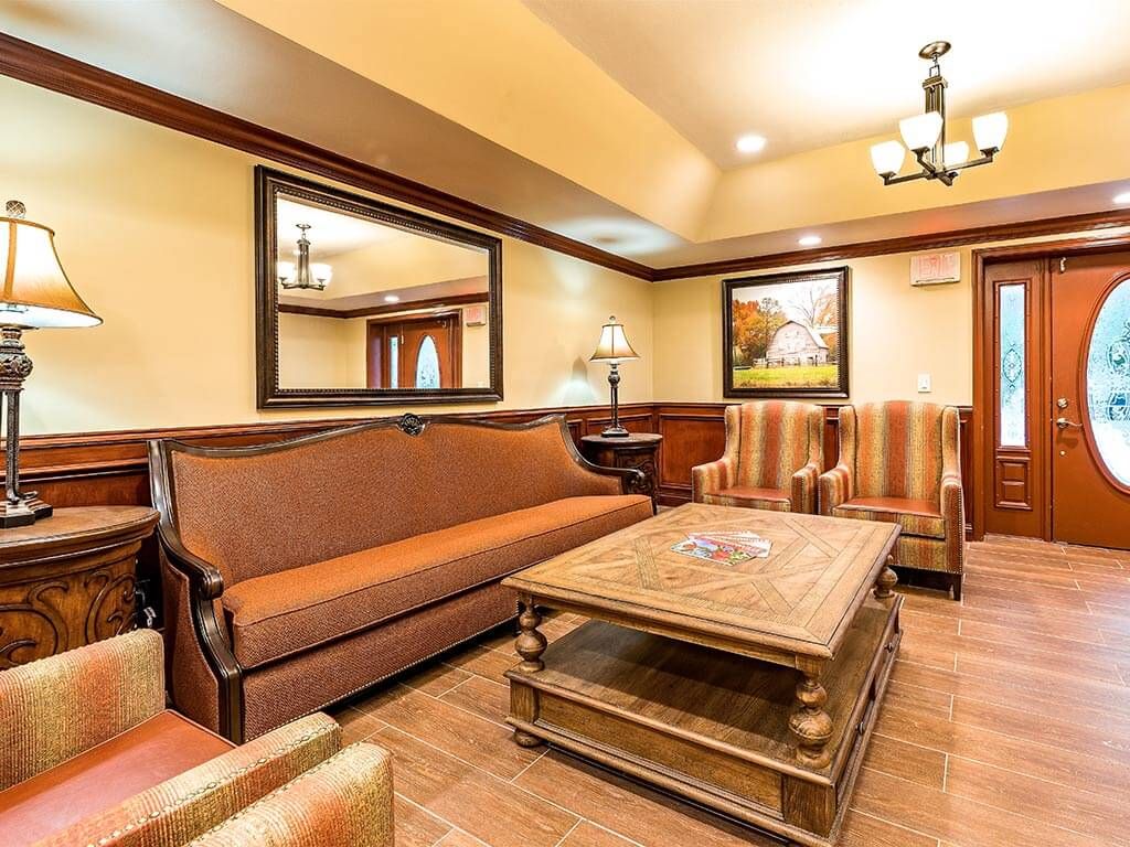 A cozy living room with a brown sofa, armchairs, and a wooden coffee table.