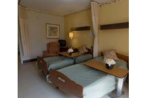 A hospital room with two beds and medical equipment.