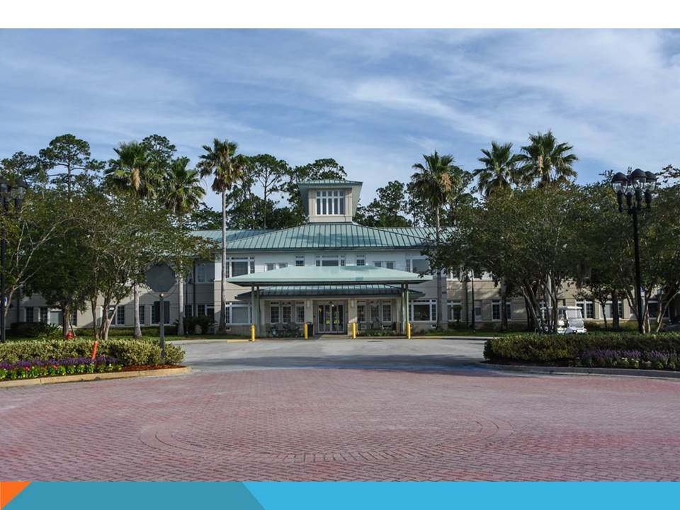 A resort building with palm trees lining the entrance.