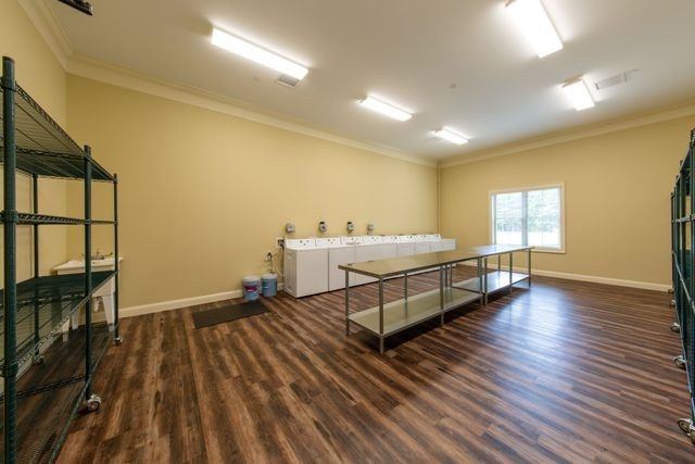 A spacious laundry room with multiple washing machines and a large folding table.