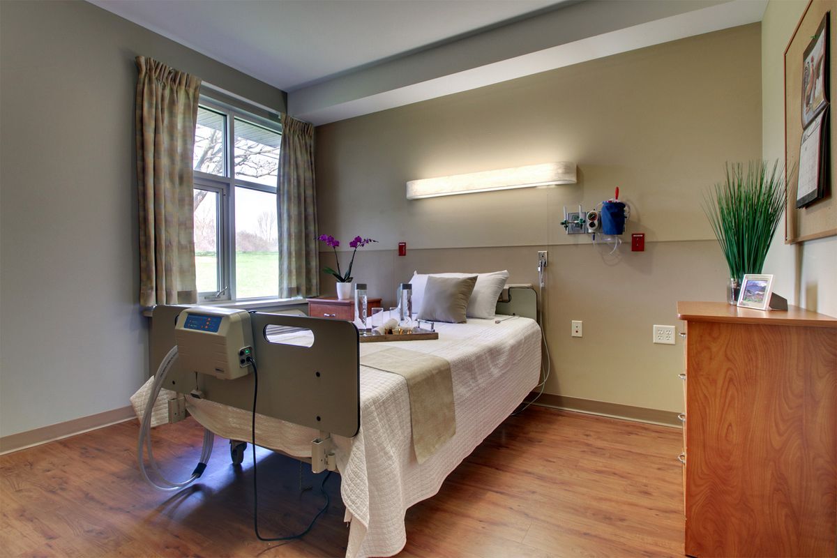 A clean and well-lit hospital room with a bed and medical equipment.