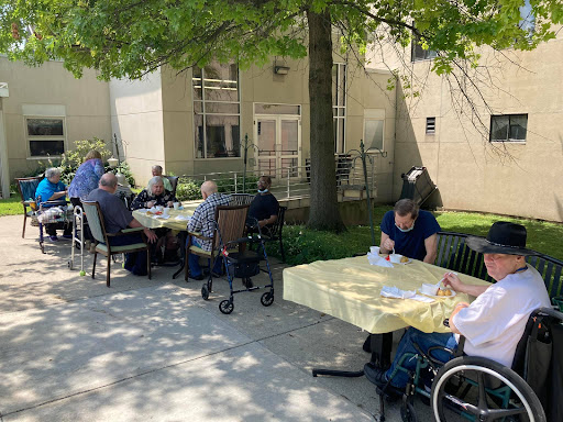 Seniors gathering outdoors for a social activity on a sunny day.