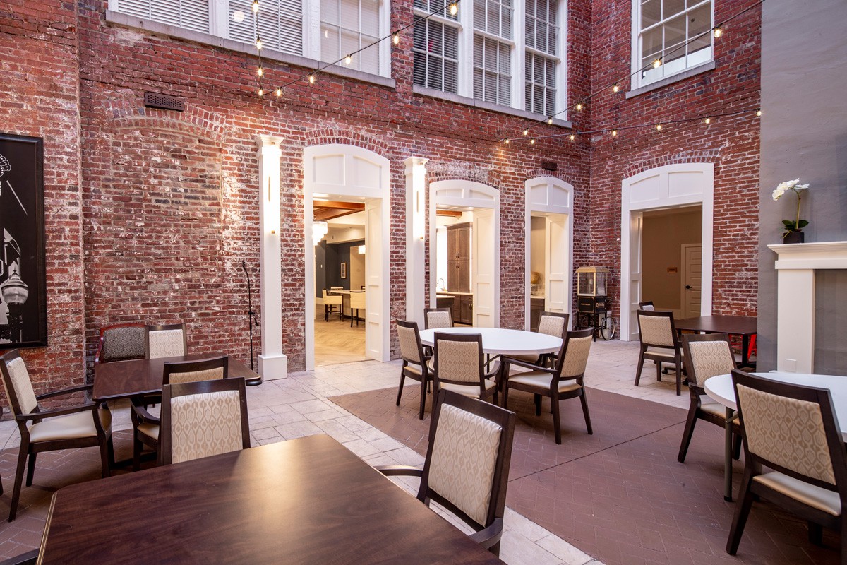 A cozy courtyard with string lights and comfortable seating, perfect for an evening gathering.