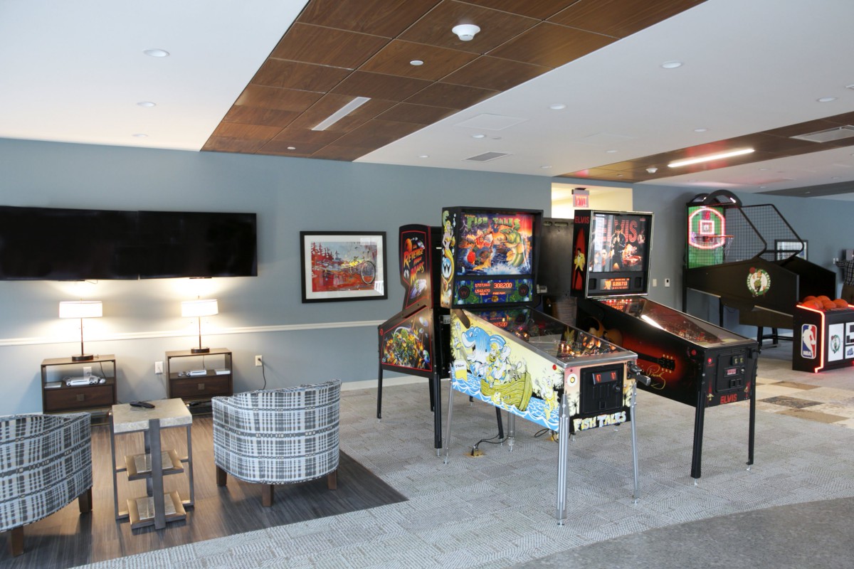 A recreational room featuring multiple pinball machines and a seating area.