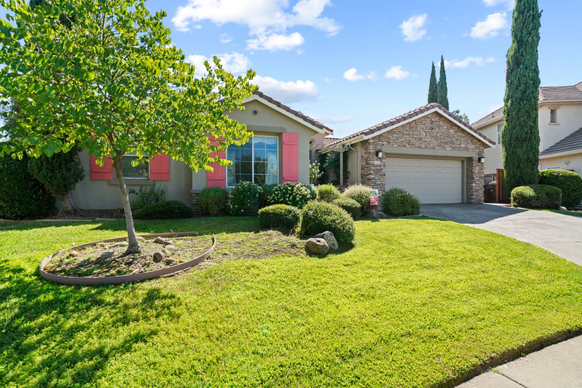 A suburban house with a well-maintained lawn and landscaping.