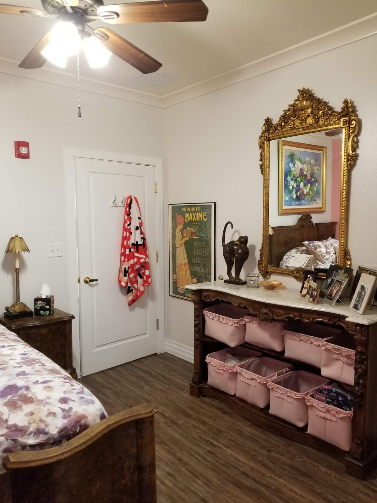 A cozy bedroom corner with ornate mirror and storage bins.