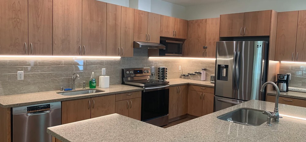 A modern kitchen with wood cabinets and stainless steel appliances.
