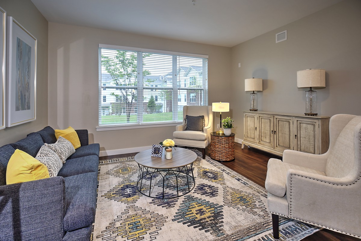 A modern and cozy living room with stylish furniture and a large window.