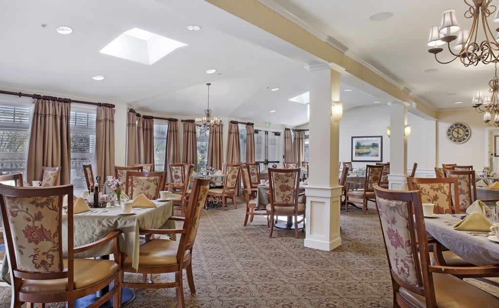 A spacious and elegantly decorated dining room with neatly arranged tables and chairs.