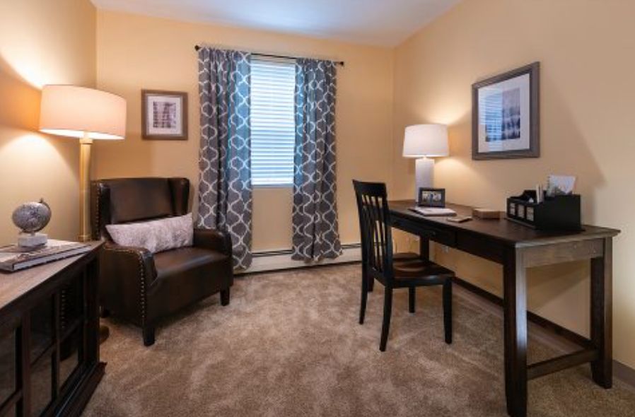 A cozy home office with a desk, chair, and decorative elements.