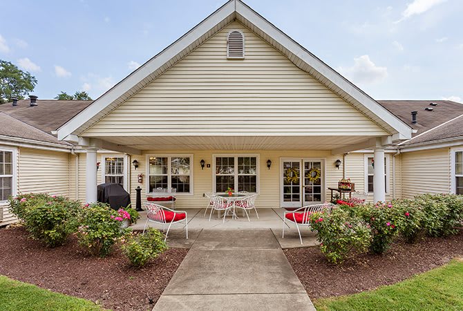 A suburban house with a spacious patio and outdoor seating area, surrounded by a well-maintained garden.
