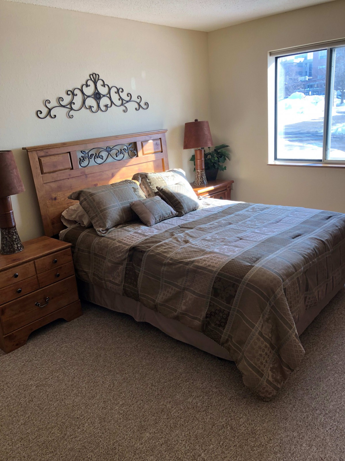 A cozy and well-decorated bedroom with a large bed and wooden furniture.