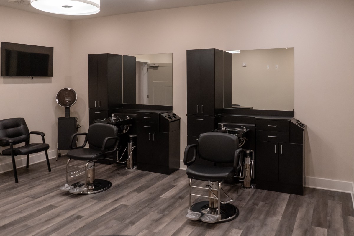 A modern hair salon with chairs and mirrors.