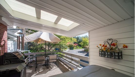 A cozy patio with outdoor seating under a skylight, complemented by a garden view.