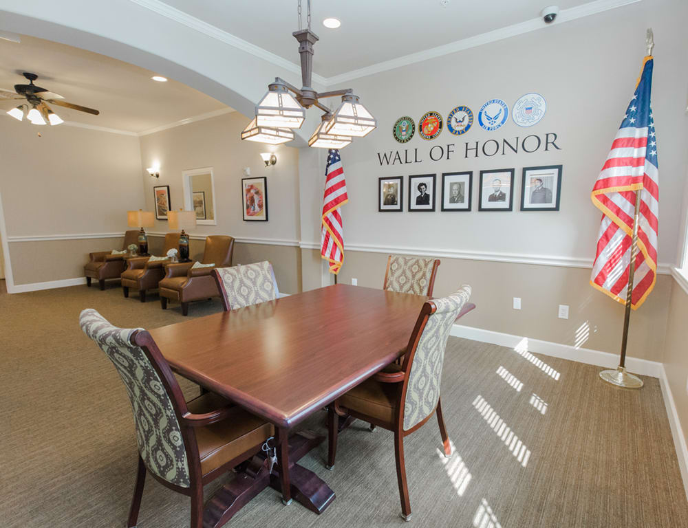 A well-appointed meeting room featuring a conference table, chairs, and patriotic decor, including American flags and a 'Hall of Honor' display with framed photos.