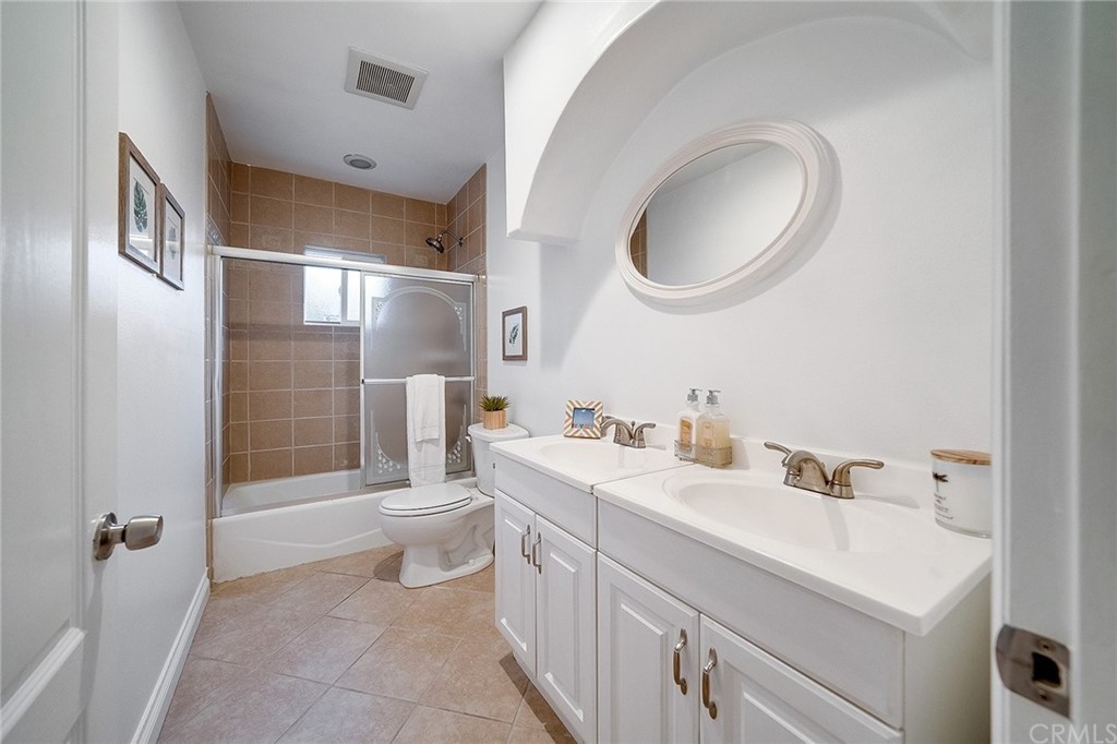 A modern bathroom with double sinks and a bathtub.