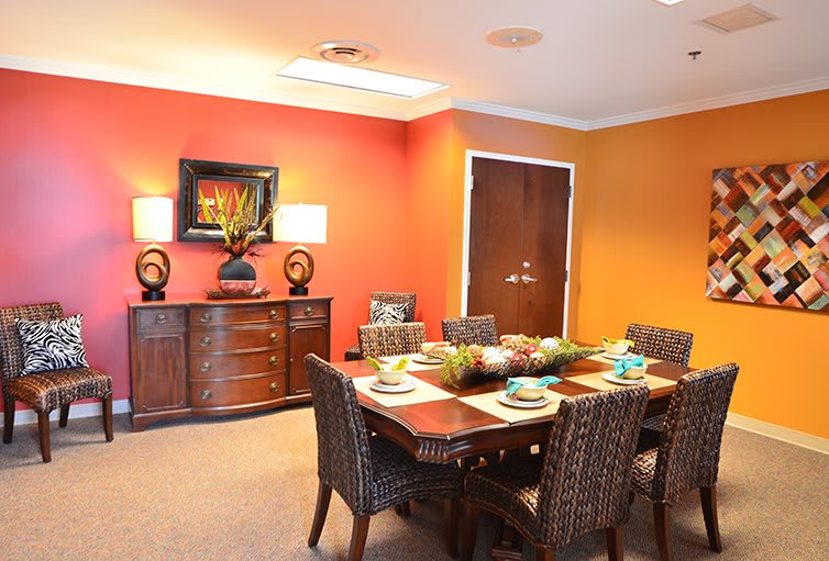A warmly decorated dining room with a set table and vibrant walls.