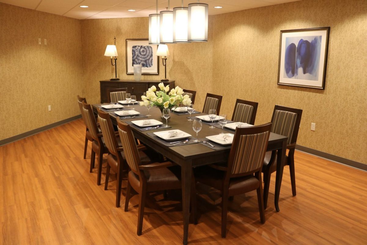 A well-decorated dining room with a large table, chairs, and modern lighting.
