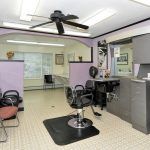 Interior of a hair salon with styling chairs, mirrors, and a waiting area.