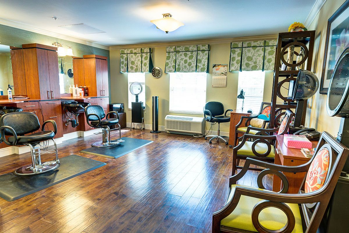 A bright and inviting hair salon with stylish chairs and a wooden floor.