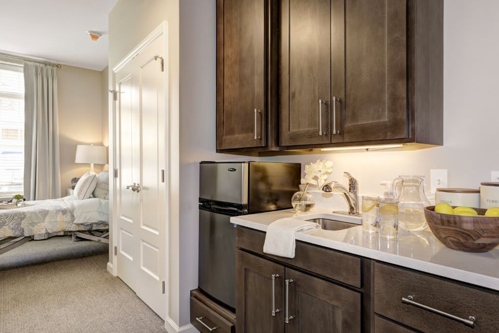A modern kitchen with dark cabinets and stainless steel appliances.