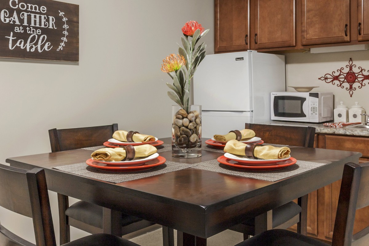 A cozy dining area with a neatly set table and floral centerpiece.