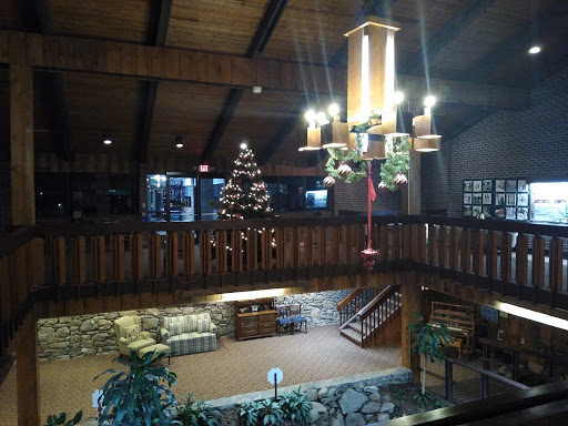 A welcoming interior lobby featuring a Christmas tree, wooden architecture, and warm lighting.