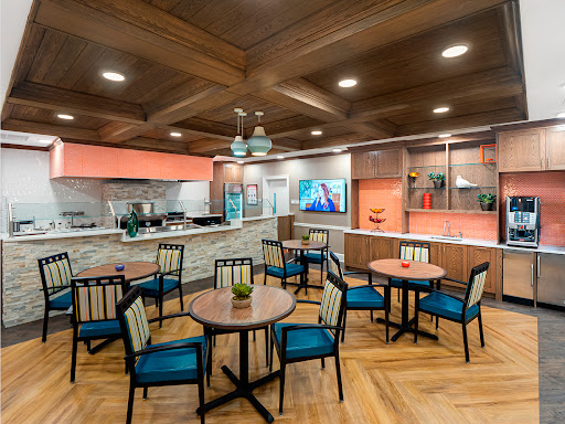 A modern dining area featuring a cozy layout with wooden accents and a kitchen view.
