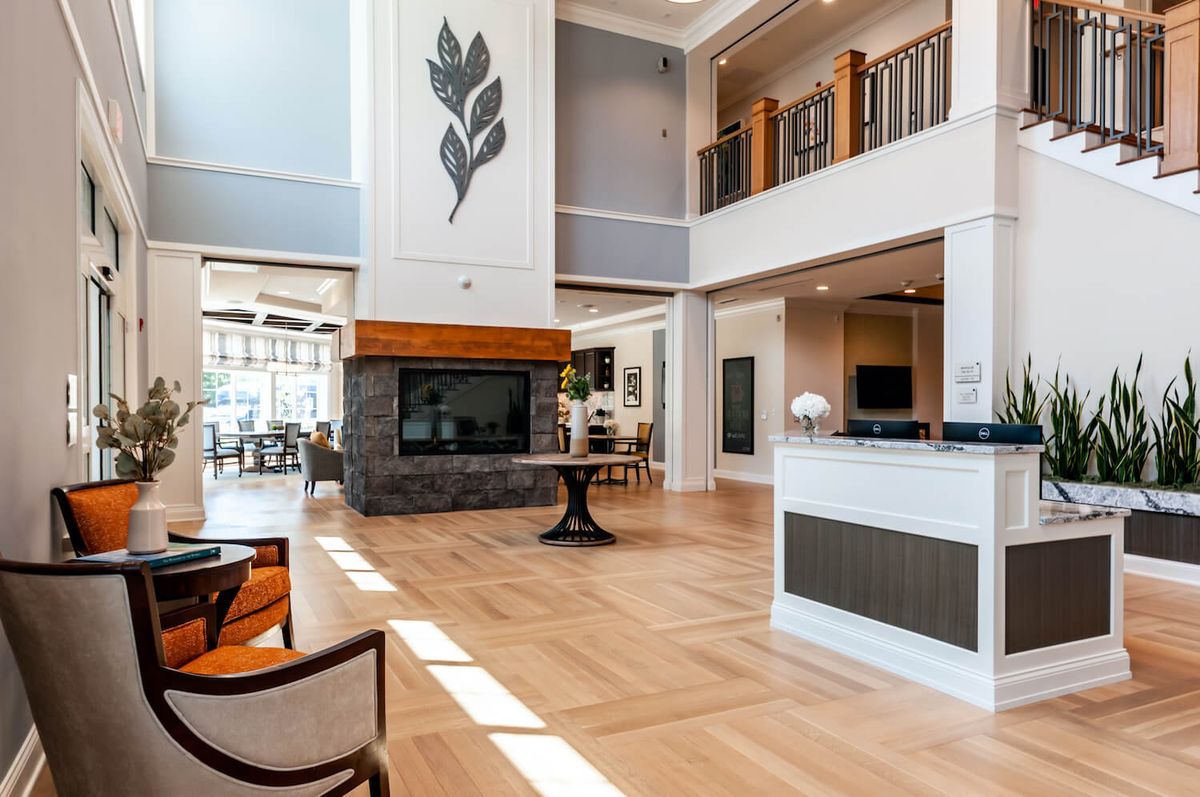 A modern and spacious lobby with high ceilings, featuring wood flooring and stylish furniture.