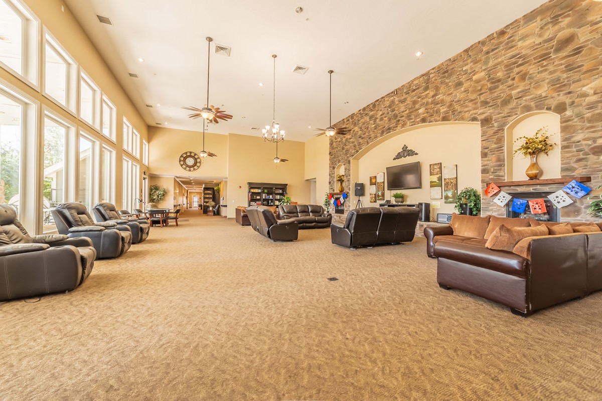 A spacious lounge area with comfortable seating and large windows.