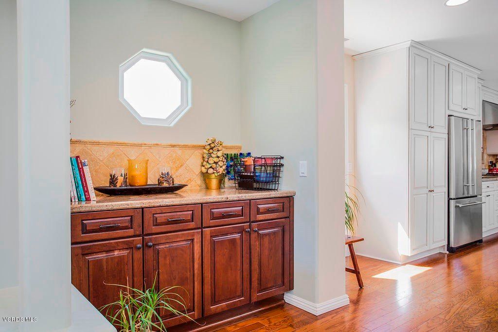 A cozy home interior with wooden cabinets and a small window letting in sunlight.