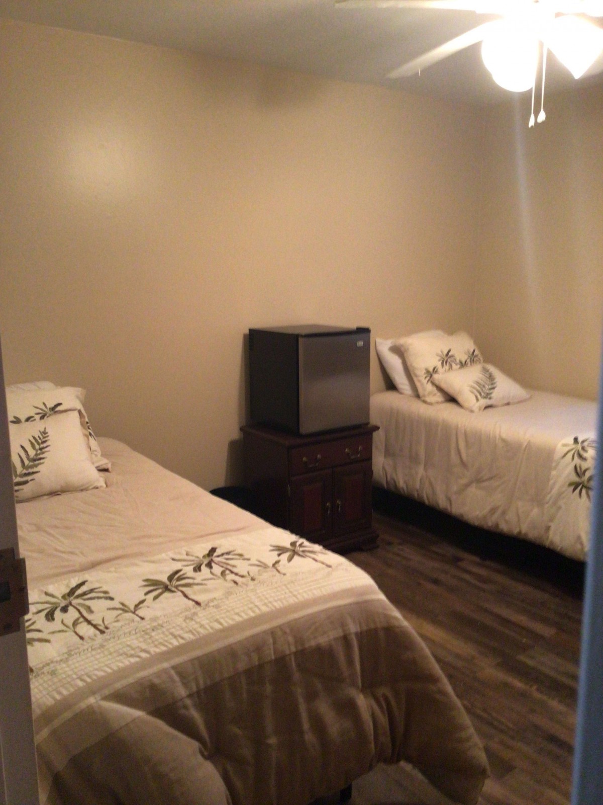 A small bedroom with two single beds and minimalistic decor.