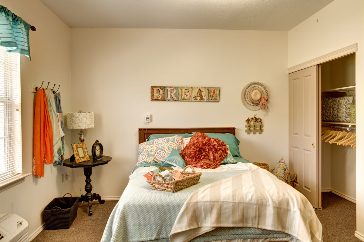Cozy bedroom with floral decor and wall art.