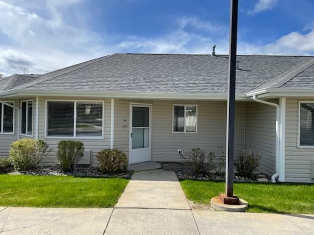 A single-story house with a small front yard and clear blue sky.