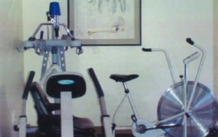 A home gym setup with a stationary bike and other exercise equipment.