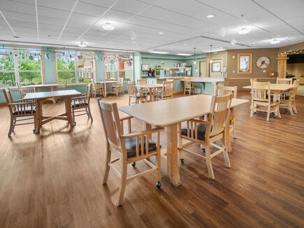 A spacious and well-lit dining area featuring wooden furniture and ample natural light.