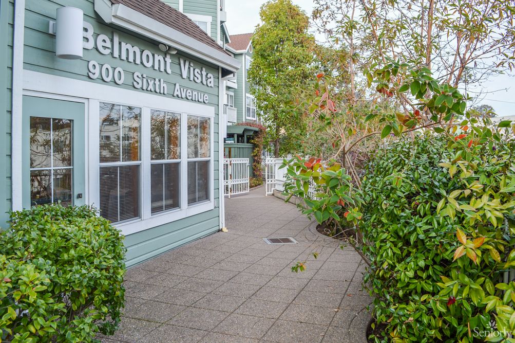 A building with signage surrounded by greenery and a pathway.