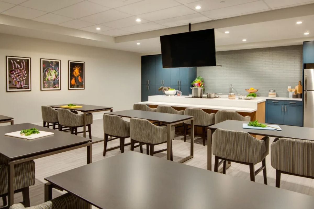 A modern meeting room with sleek furniture, a large TV screen, and decorative artwork on the walls.