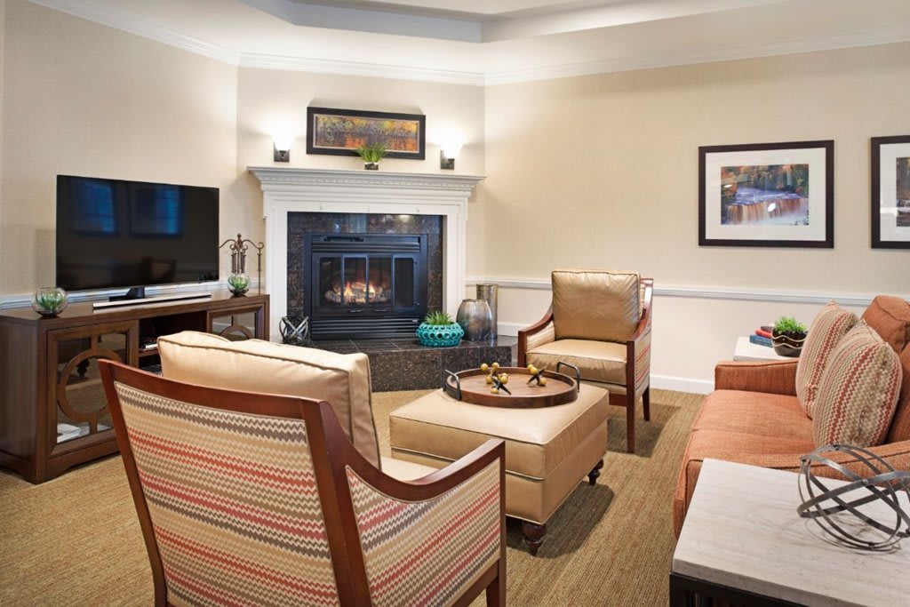 A cozy living room with a fireplace, stylish furniture, and a television.