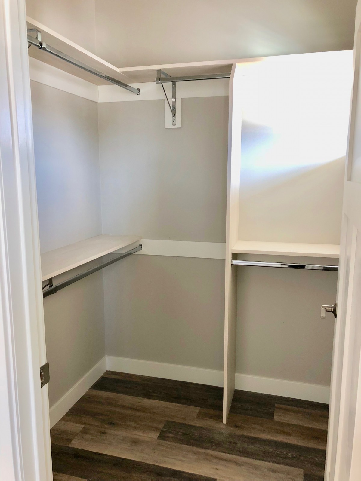 An empty walk-in closet with hanging rods and shelves.