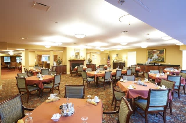 An empty dining room with neatly arranged tables and chairs.