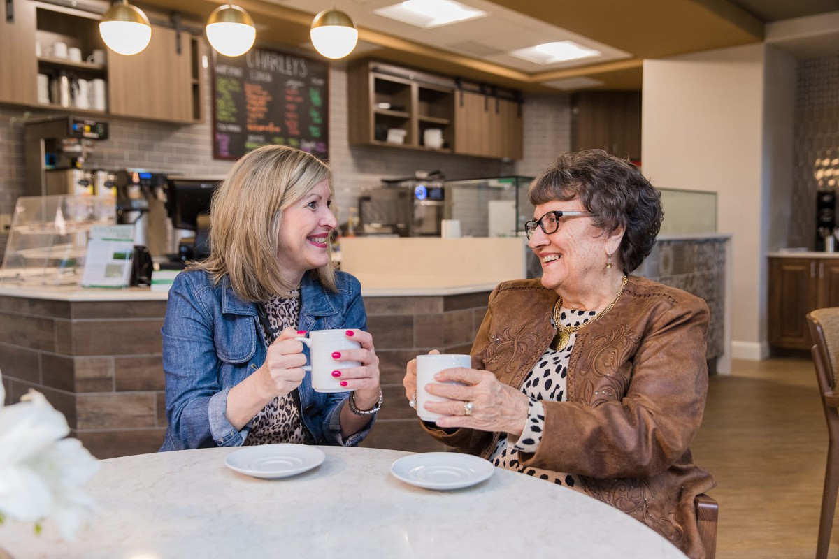 Two women enjoying a conversation over coffee in a cozy caf.