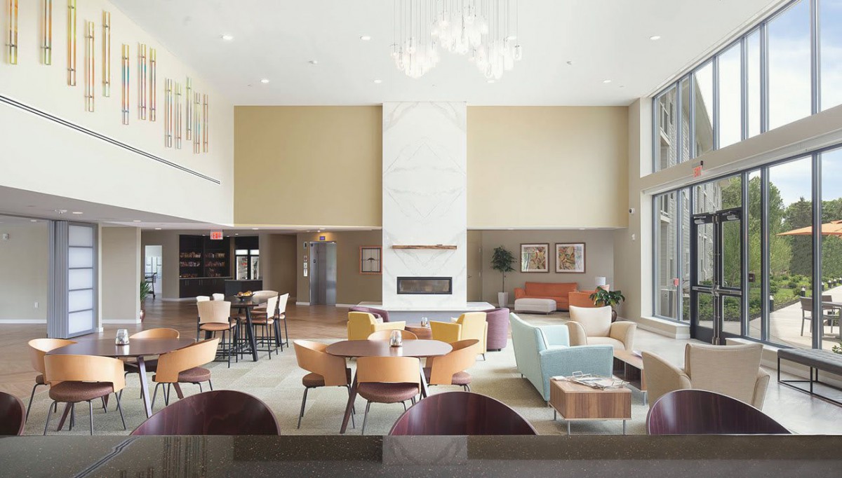 A spacious, modern lobby with comfortable seating and a central fireplace.