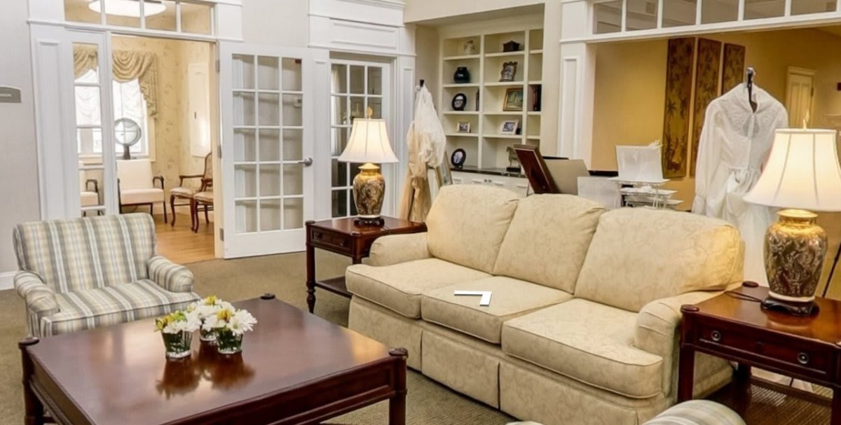 A cozy living room with a beige sofa, wooden coffee table, and bookshelves.