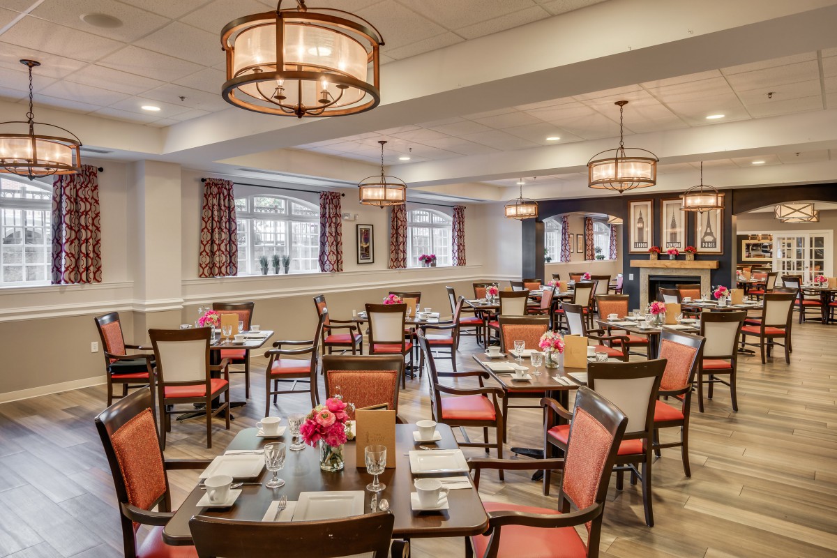 A spacious and elegantly decorated dining room with neatly arranged tables and chairs.