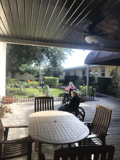 A serene outdoor space at a care facility with seniors enjoying the garden.