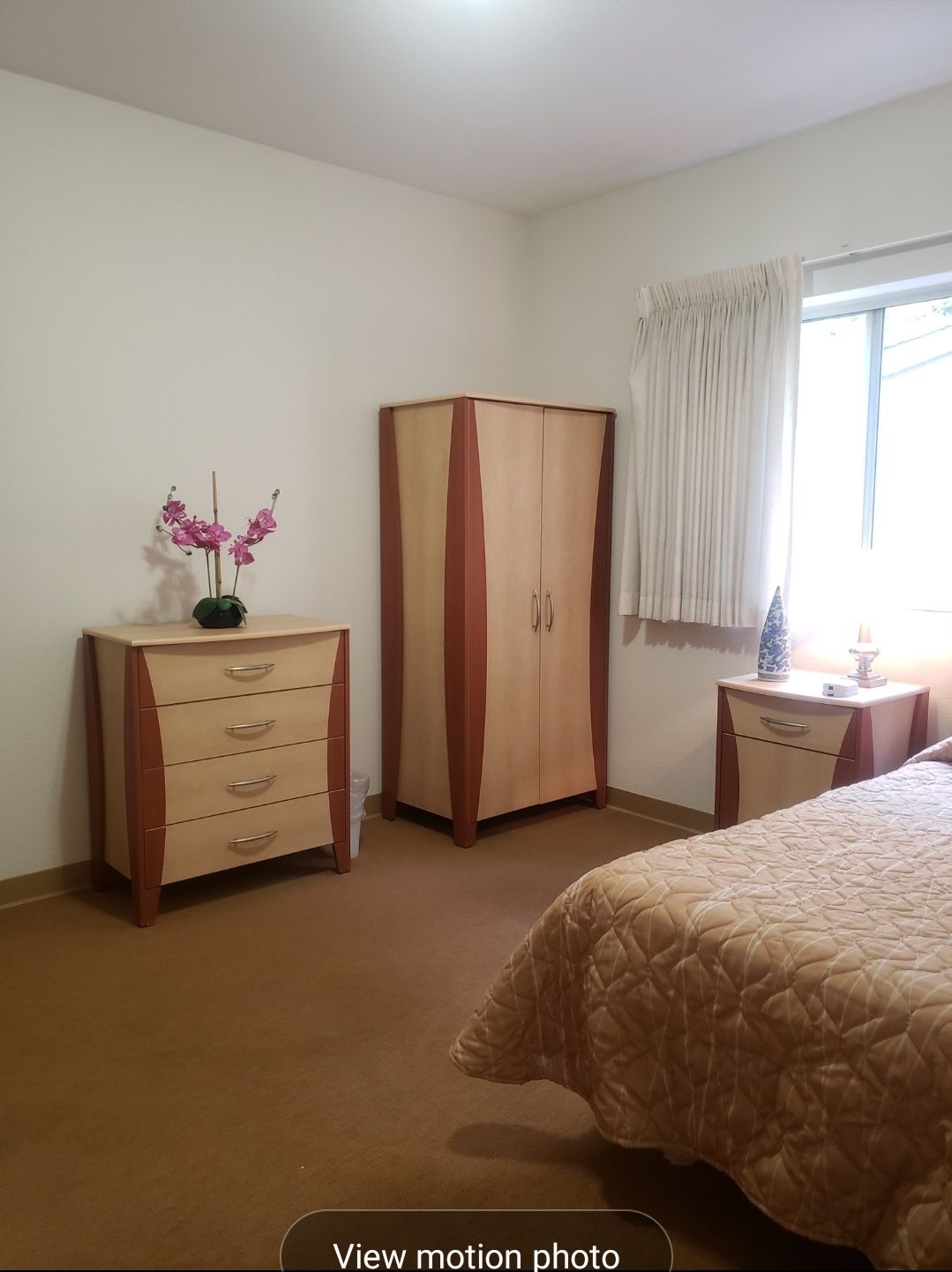 A tidy bedroom with matching furniture and floral decor.