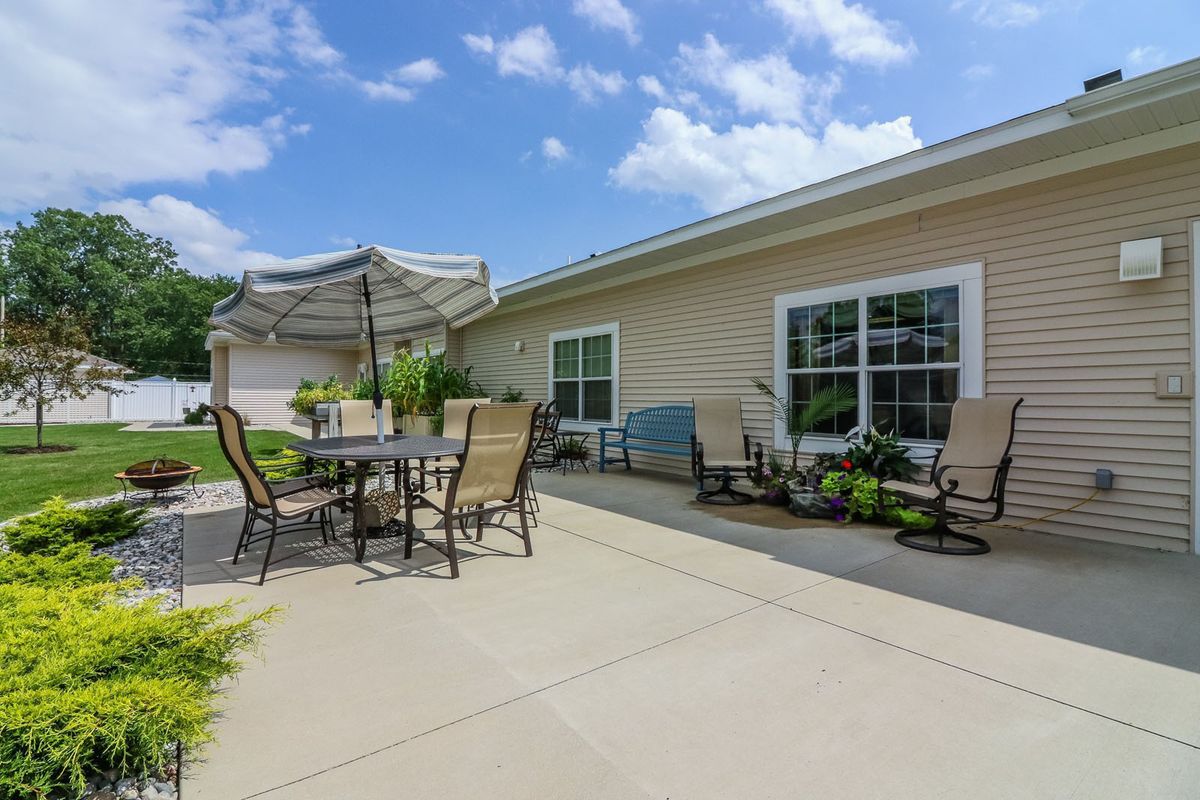 A spacious patio with outdoor furniture under a bright blue sky.